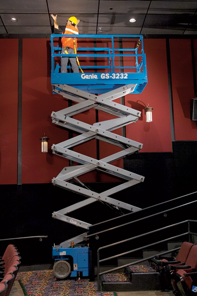 Genie electric scissor lift GS-3232 with inline outriggers working in a cinema